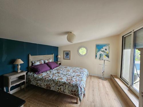 une chambre avec un lit et un mur bleu dans l'établissement La Govelle, au Pouliguen