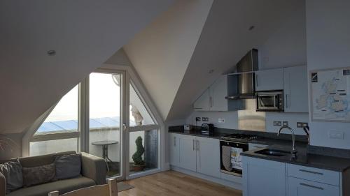 a kitchen with a couch and a large window at Tate Five Penthouse apartment with panoramic views of St Ives in St Ives
