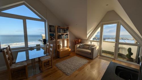 a living room with a view of the ocean at Tate Five Penthouse apartment with panoramic views of St Ives in St Ives