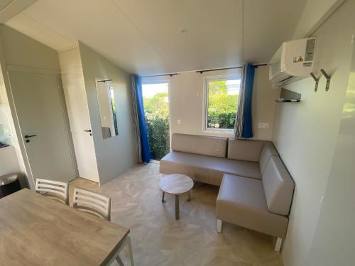 a small room with a couch and a table at Camping Le Tarteron in Le Crotoy