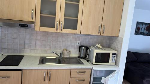 a kitchen with a sink and a microwave at Apartments Branimir in Murter