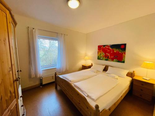 a bedroom with a bed and a window at Ferienwohnungen in Hollern-Twielenfleth in Hollern-Twielenfleth