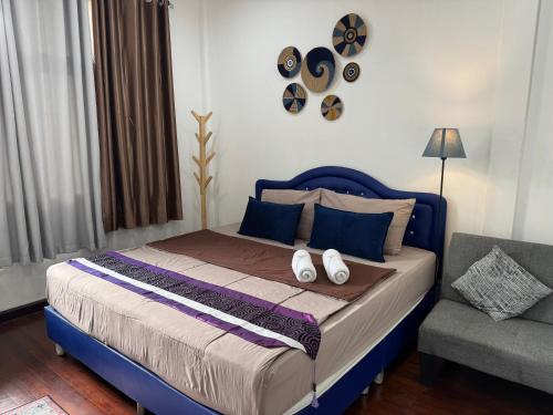 a bedroom with a bed with a blue headboard and a chair at Twenty One Place in Bangkok