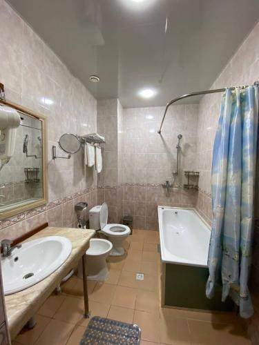 アンディジャンにあるHamkor hotelの洗面台、浴槽、トイレを備えたバスルーム