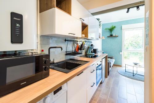 une cuisine avec des armoires blanches et un évier dans l'établissement NEW Le Duplex au Coeur de Ville PARKING Privé, à Guingamp