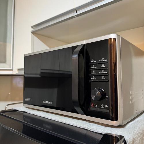 a microwave oven sitting on top of a kitchen counter at Cozy Haven - Newport - Walking distance to NAIA T3 in Sampong