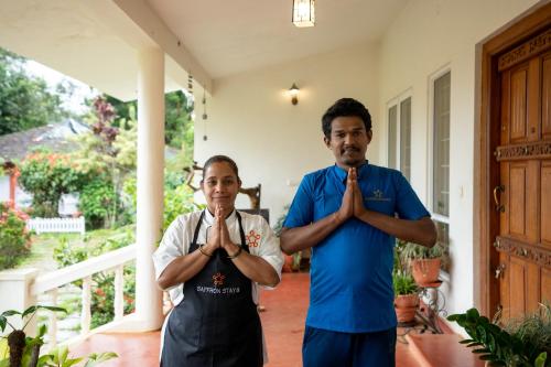 a man and a woman praying in a house at SaffronStays Robin Woods in Kenchamman Hoskota