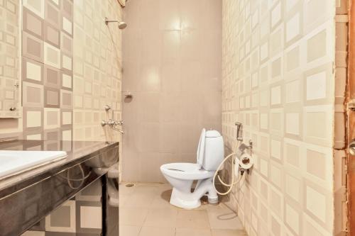 a bathroom with a toilet and a sink at SaffronStays Robin Woods in Kenchamman Hoskota