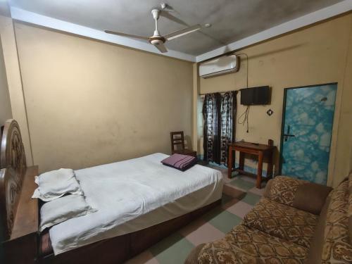 a bedroom with a bed and a chair and a ceiling fan at City Abashik Hotel 