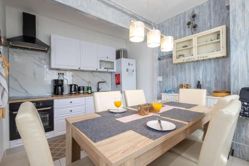 a kitchen with a wooden table and white cabinets at Apartmani Simona Tribunj in Tribunj