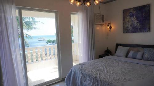 ein Schlafzimmer mit Bett und Blick auf das Meer in der Unterkunft Ohana Semeistvo Beach house in Sampong