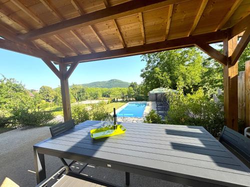 - une table de pique-nique en bois avec vue sur la piscine dans l'établissement Les Maisons de Jeanne, à Saint-Vincent-de-Cosse