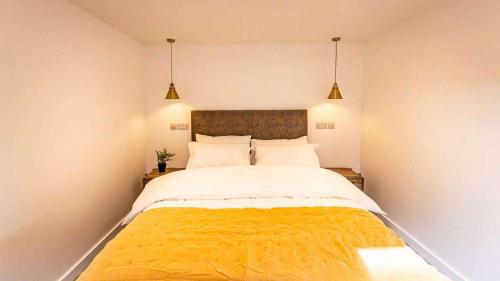 a bedroom with a large bed with a yellow blanket at Whitemills Wake and Aqua Park Lodge Three in Richborough
