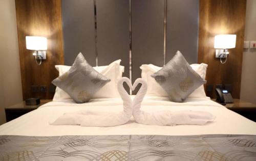 a bed with two white towelsrendered to look like swans at Golden Season Hotel - Al-Rass - فندق جولدن سيزون - الرس in Al Rass