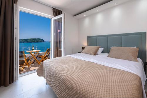 une chambre avec un grand lit avec vue sur l'océan dans l'établissement Amazing beach villa Becir stay - Molunat near Dubrovnik, à Molunat