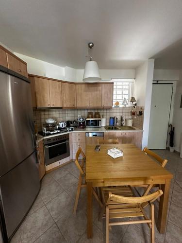 a kitchen with a wooden table and a refrigerator at Saronida Beachwalk Stay in Saronida