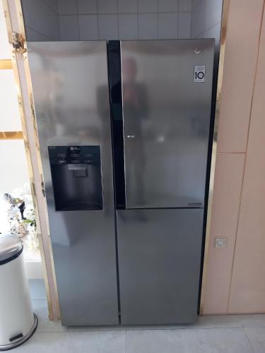 a stainless steel refrigerator in a kitchen at Chalet with waterfront sauna and boat in Loosdrecht