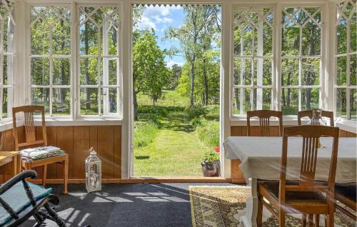Arkösundにある4 Bedroom Gorgeous Home In Vikbolandetのテーブルと大きな窓のある部屋