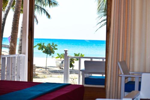 a room with a view of the beach from a hotel room at Golden Beach Cottages in Trincomalee