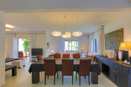 a dining room and living room with a table and chairs at VILLA avec Rooftop Bahia Smir bord de mer in Fnidek