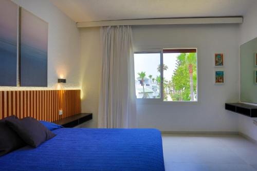 a bedroom with a blue bed and a window at VILLA avec Rooftop Bahia Smir bord de mer in Fnidek