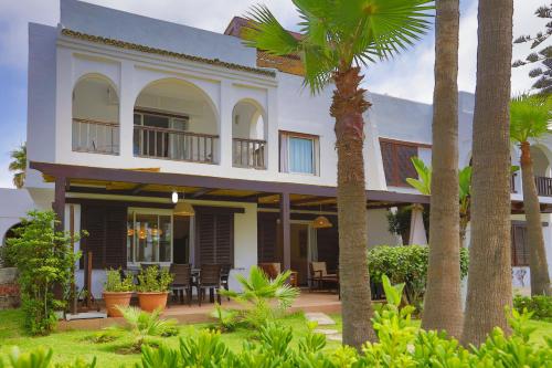a house with palm trees in front of it at VILLA avec Rooftop Bahia Smir bord de mer in Fnidek