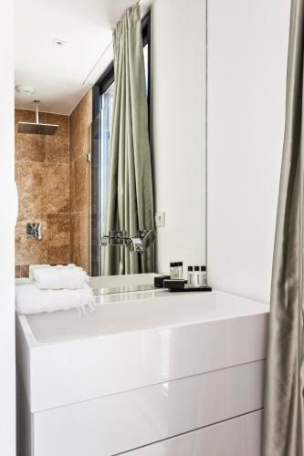 une salle de bain blanche avec un lavabo et un miroir dans l'établissement Azure Apartment, à La Croix-Valmer