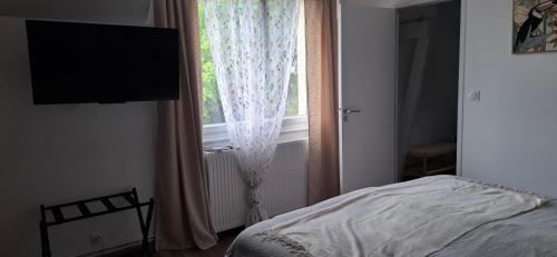a bedroom with a bed and a window at Les Escales de Marion in Le Val-Saint-Père