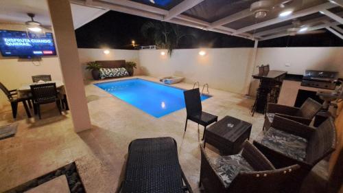 a swimming pool in a room with chairs and a table at Malaga Herradura #25 with Private Pool in Herradura