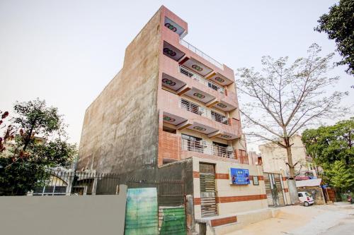 un edificio de ladrillo alto con una valla delante en Hotel O DS Palace, en Indirapuram