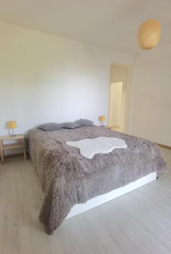 a bedroom with a large bed with a blanket at Honey Factory House in Santa Cruz