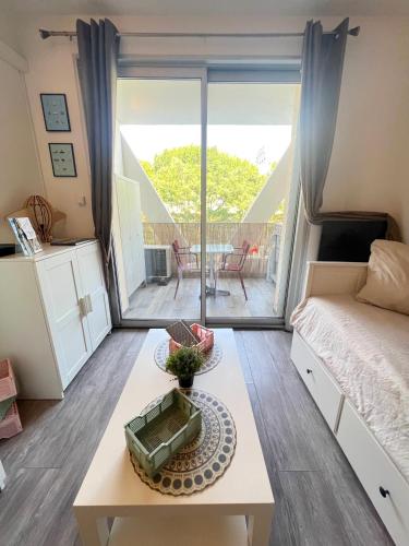 - une chambre avec un lit, une table et un balcon dans l'établissement Studio Rock wood, à La Grande Motte