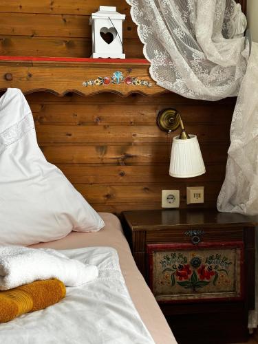 a bedroom with a bed and a table with a lamp at Pension Magdalena in Altossiach