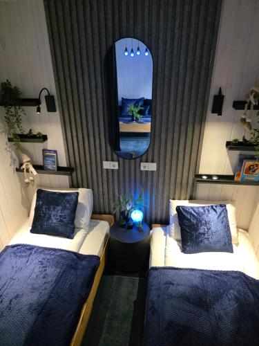 a room with two beds and a mirror and a tv at Economy rooms for 2-4 people in Anykščiai