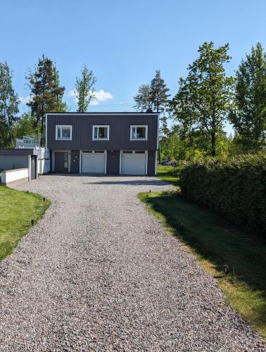 a house with two garage doors on a gravel driveway at Cozy countryside Appartment in Örebro