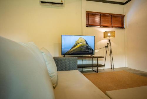 a living room with a tv and a bed and a table at Aqua Suites in Wok Tum