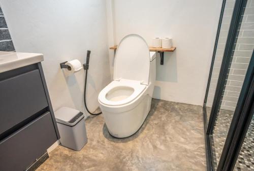 a small bathroom with a toilet and a shower at Aqua Suites in Wok Tum