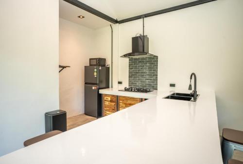 a kitchen with a sink and a refrigerator at Aqua Suites in Wok Tum
