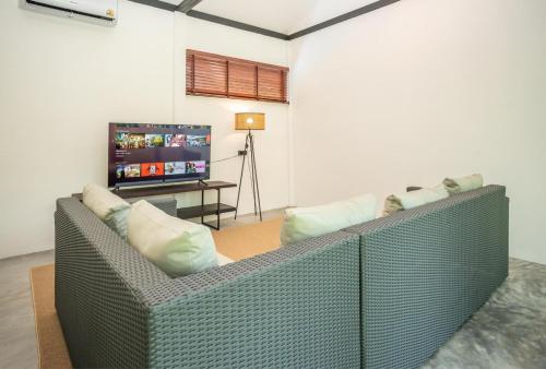 a living room with a couch and a flat screen tv at Aqua Suites in Wok Tum