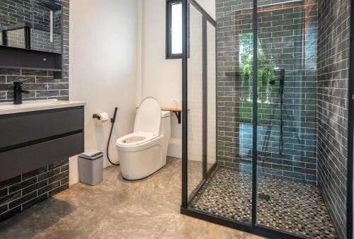a bathroom with a toilet and a glass shower at Aqua Suites in Wok Tum
