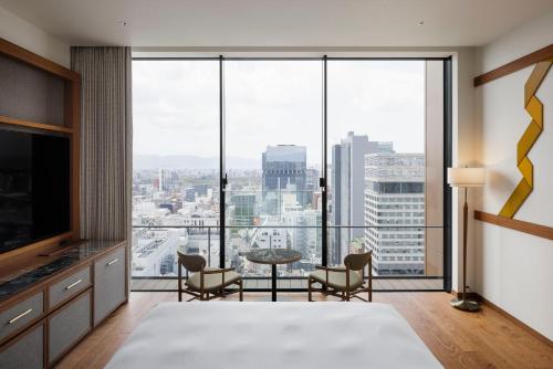 a bedroom with a view of a city at One Fukuoka Hotel in Fukuoka