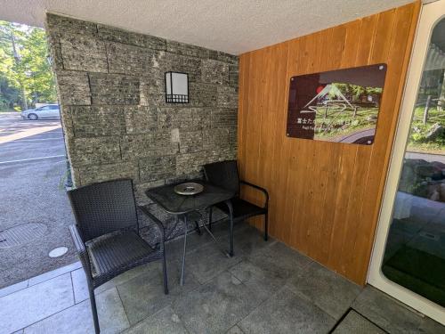 a small table and two chairs on a patio at 富士たから荘 旭日館 in Yamanakako