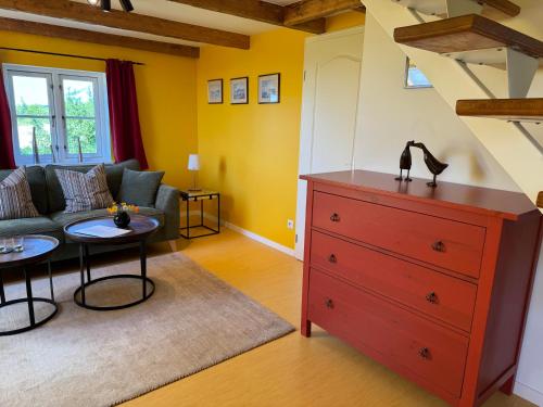 a living room with a couch and a red dresser at Vogelhaus Gobbin in Lancken-Granitz