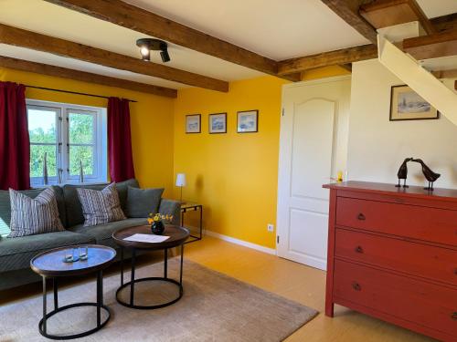 a living room with a green couch and a red dresser at Vogelhaus Gobbin in Lancken-Granitz
