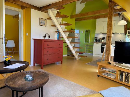 a living room with green walls and wooden beams at Vogelhaus Gobbin in Lancken-Granitz