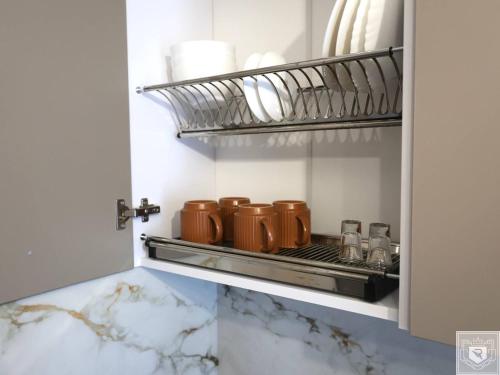 a cupboard with four brown coffee cups in it at RentHouse Apartments - Airport Loft in Chişinău