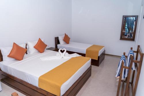 two beds sitting in a room with at US Cabanas in Nilaveli