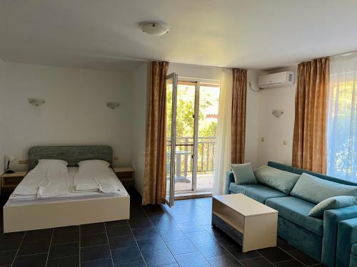 a living room with a blue couch and a table at Limani Guest house in Sozopol