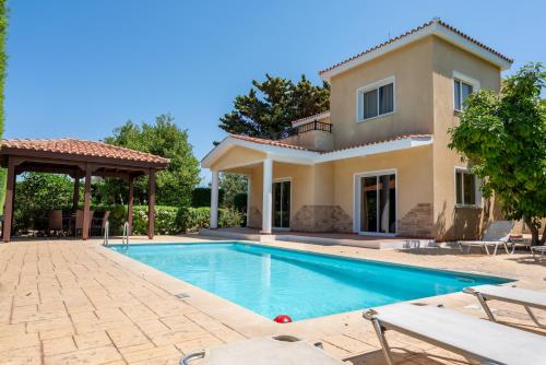 a villa with a swimming pool and a house at Villa Aspasia in Peyia, Private Pool & 3 Ensuite Bedrooms in Paphos