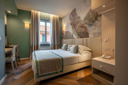 a hotel room with a bed and a desk and a window at Hotel Monte Rosa in Chiavari